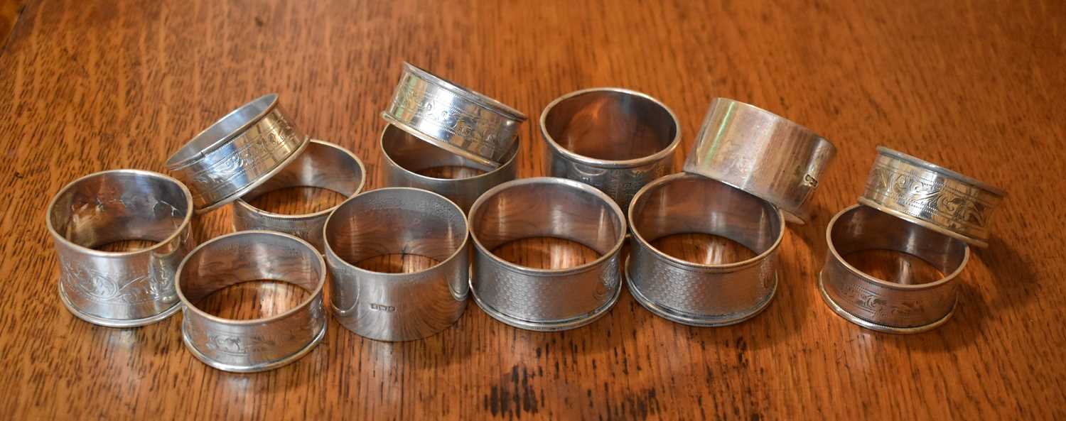 A group of thirteen silver napkin rings of various form and design including a set of six, 7.9 toz