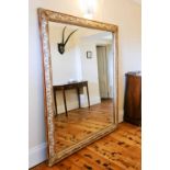 A large 19th century gilded and painted hall / wall mirror, carved with decoration, 176 by 143cm.