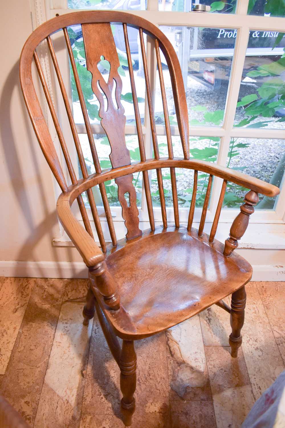 A 19th century elm Windsor armchair, with hoop back and bowed arm rail pierced with spindles, the