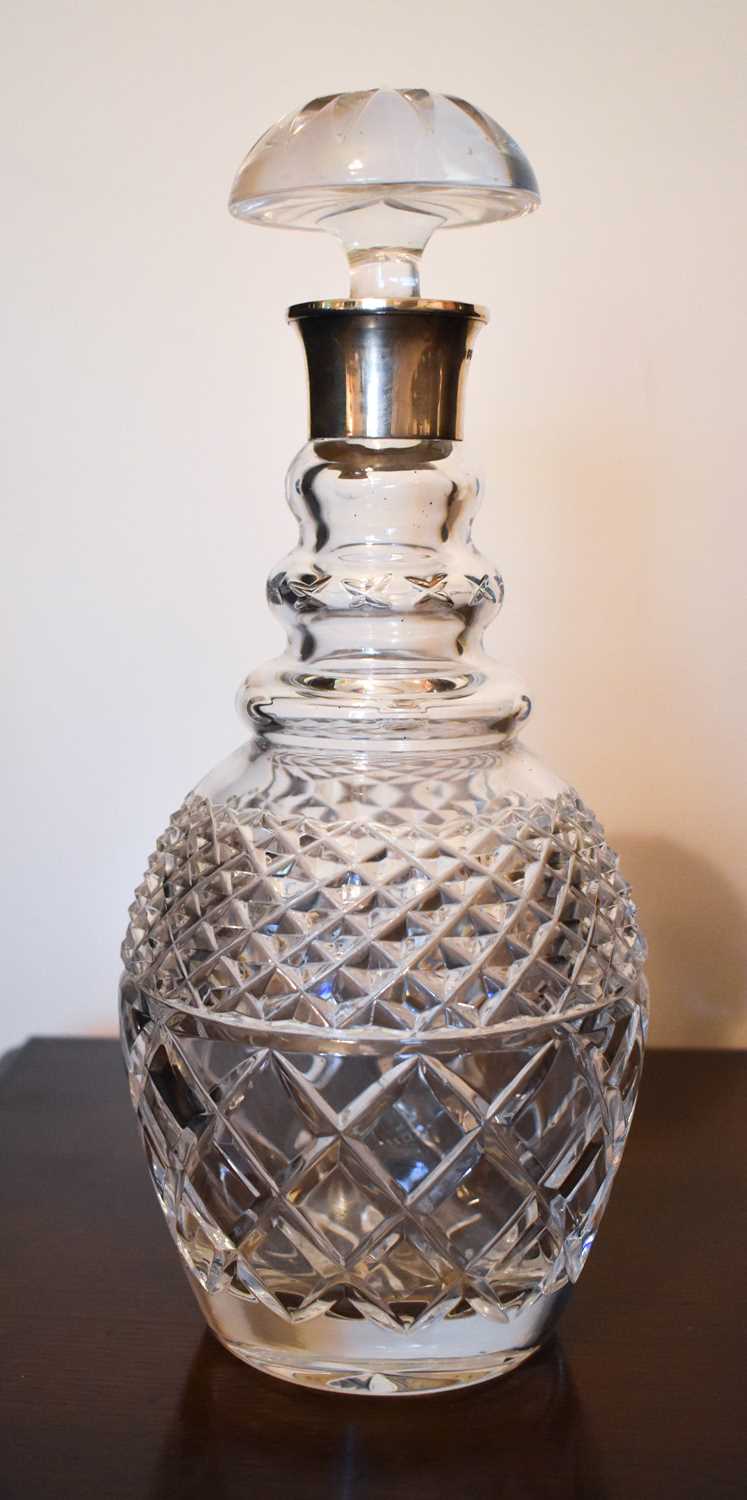 A cut glass decanter with silver collar and original mushroom form stopper, London.