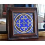 A framed ceramic tile in blue and gold, 15cm by 15cm