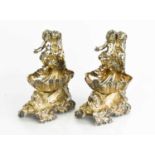 A 19th century pair of silver plated shell form salts, modelled with cherubs, and raised on