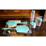 An Art Deco silver and guilloche enamel turquoise dressing table set comprising hairbrush, hand