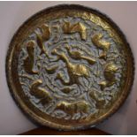 A 19th century eastern brass embossed charger decorated with various animals and a portrait in