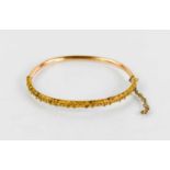 An 18ct gold bangle, with beaded decoration, 7.66g.