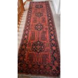 A Turkish red ground early 20th century runner with stylised foliate motifs and dark blue border ,