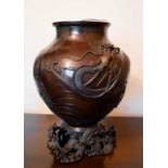 A early 19th century Chinese bronze vase, cast with a wrythen dragon raised on a open cast base