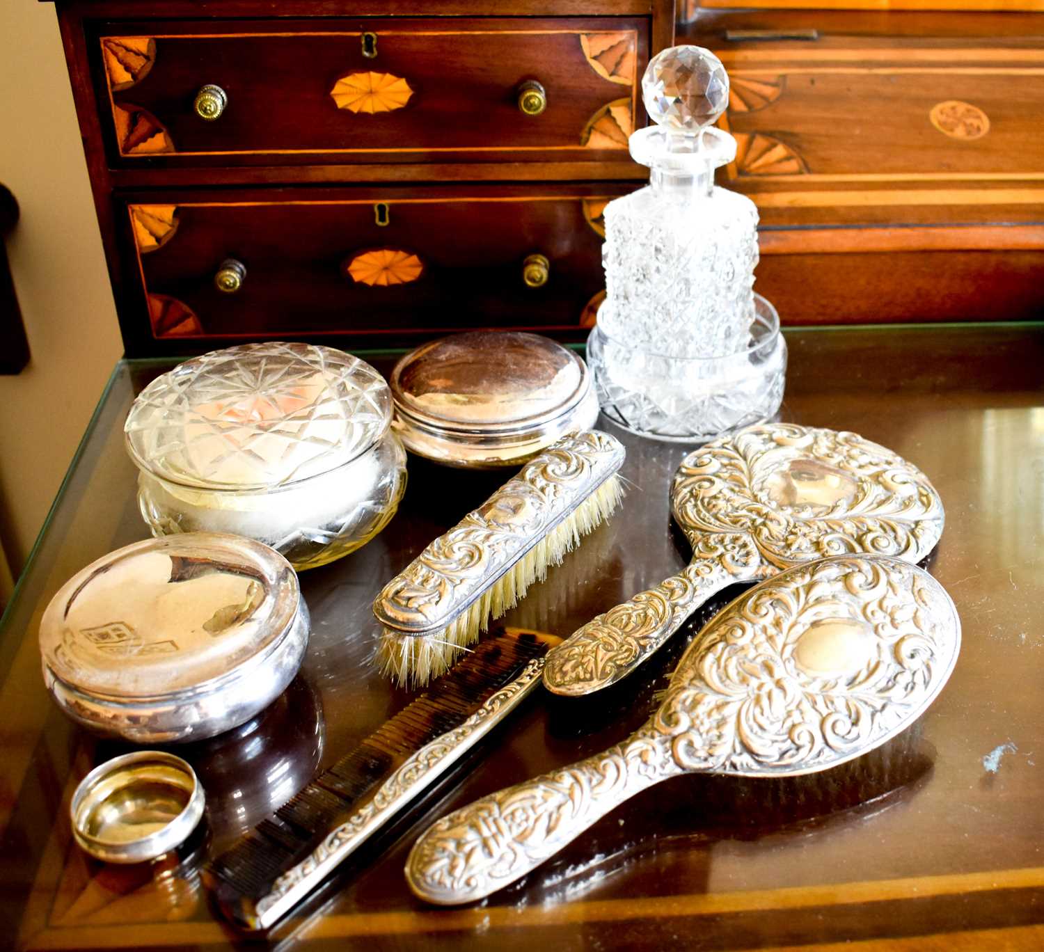 A silver hairbrush and mirror set together with a cut glass perfume bottle and other items