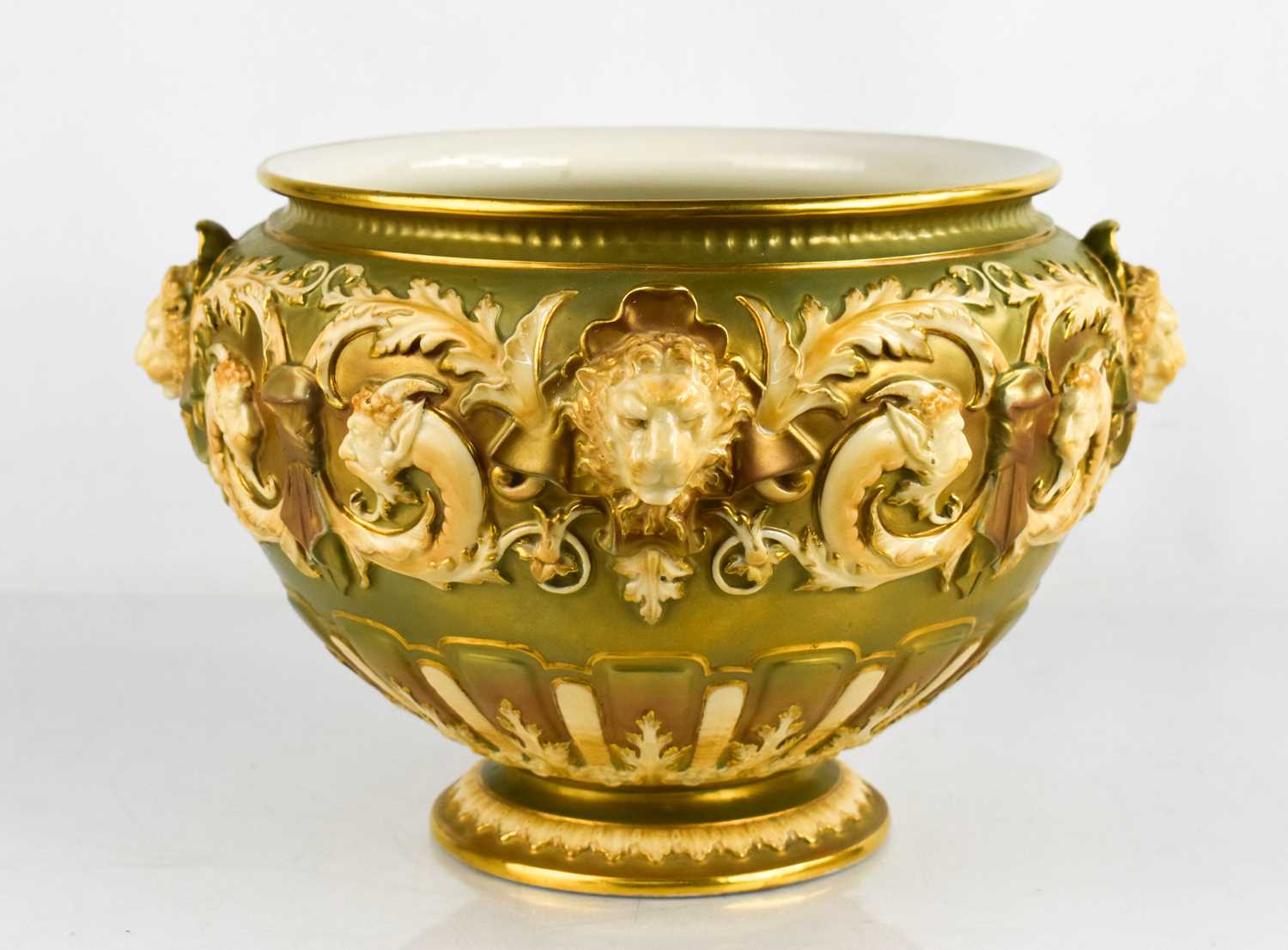 A Royal Worcester jardinere, moulded with lion masks, and scrollwork, circa 1900, 26cm diameter.