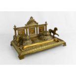 An Edwardian brass desk stand, cast with face masks and classical figures, and two lions, with two