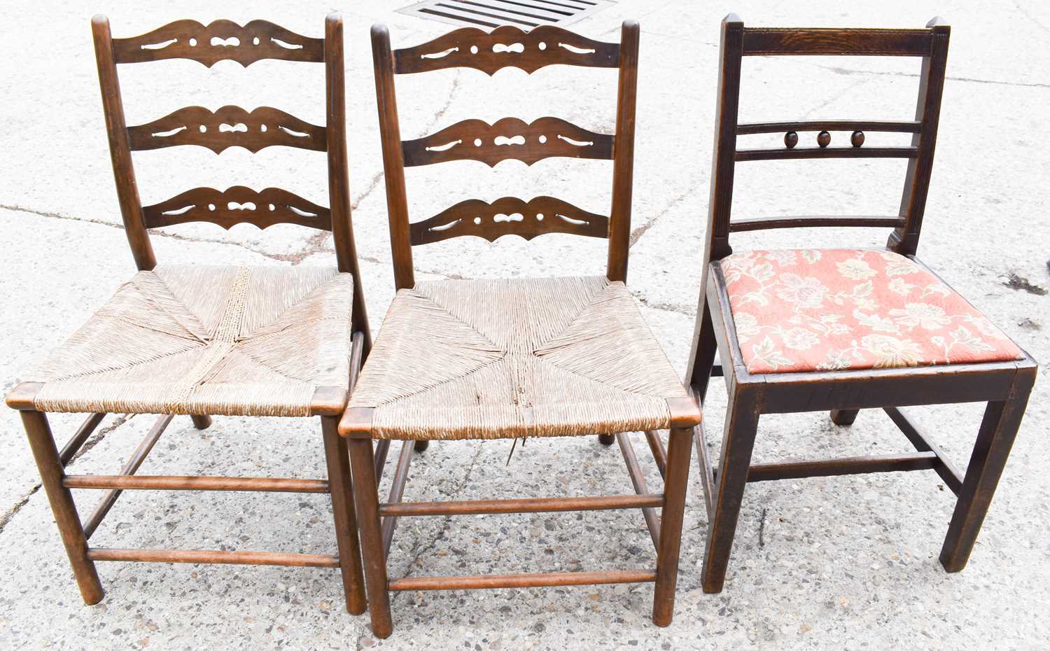 Two early 19th century ladder back chairs with rush seats together with an Edwardian upholstered