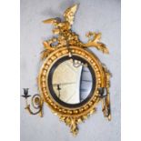 A Regency convex mirror with scrolling arm candle sconces, gilt eagle to the top and ebonised and