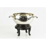 A George V twin handled rose bowl, London 1935, with the original oriental carved stand, by Boodle &