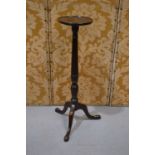 A mahogany torchere, the reeded baluster stem with palmette leaf collar and waist, on three cabriole
