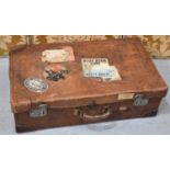 A Vintage leather suitcase in the Louis Vuitton style with labels from the Orient express and