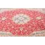 A large Middle Eastern carpet, with central red ground, with borders of cream and ochre, and