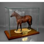A 20th century porcelain model of Red Rum, in a glass case on wooden plinth bearing a brass plaque