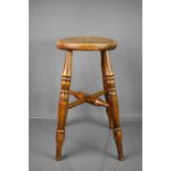 An early 19th century oak stool with circular top and x stretcher uniting turned legs, 52cm high.