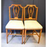 A pair of satinwood saloon chairs in the Sheraton revival style, painted with shells and foliage.