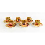 A set of six Royal Worcester coffee cans and saucers, painted with fruit on mossy ground, by