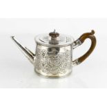 An 18th century George III teapot with foliate embossed decoration, carved wooden handle, by Charles