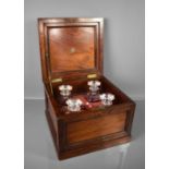 A Victorian mahogany presentation decanter box, the panelled lid opens to reveal four cut glass