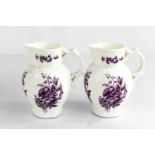 A Royal Worcester pair of small jugs, modelled with face masks, painted with purple floral sprays,