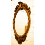 A large 18th century oval wall mirror with scroll work crested top surmounted by a scallop shell.