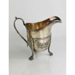 A silver footed jug, embossed with floral swags and raised on three paw feet, Chester 1913, 10.