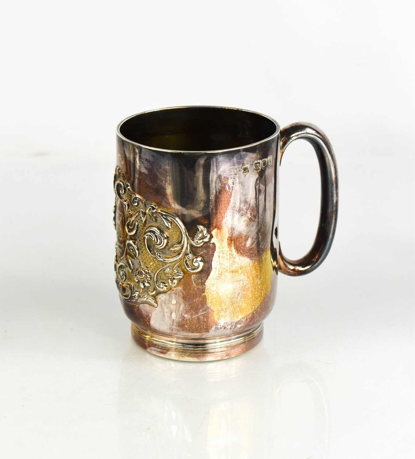 A silver mug, embossed with a crest and engraved with a monogram and dated 21st March 1900, London