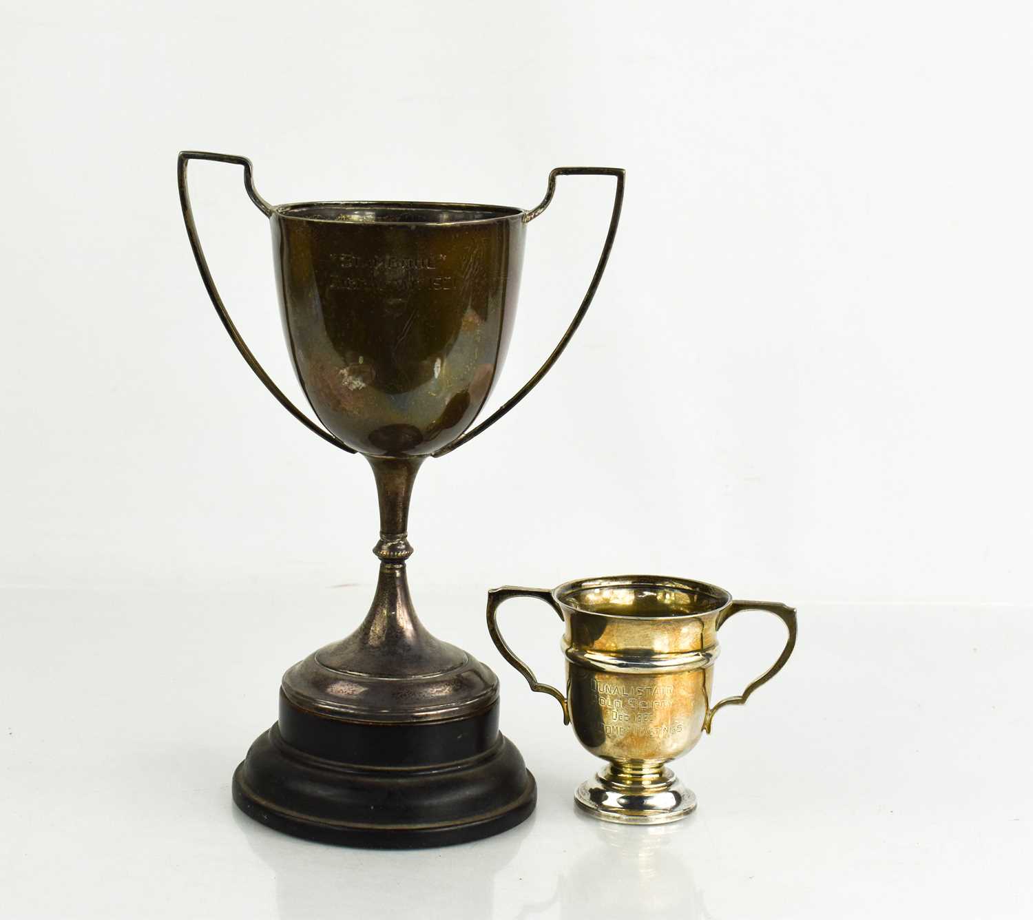 Two silver trophies, one raised on an ebonised plinth, both engraved with presentation inscriptions,