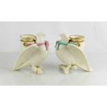 A pair of Royal Worcester porcelain spill vases, modelled as doves perched on a branch with urn to