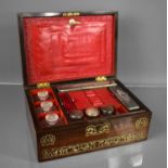 A Victorian rosewood dressing table box, with inlaid brass work to the front, fitted with five