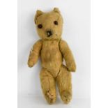 An early 20th century teddy bear, bearing makers button to the back (worn) 36cm high.