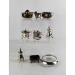 A group of silver to include salt and pepper, salts, mustard pot, sterling silver rimmed glass