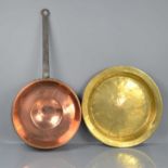 A 19th century copper and cast iron pan together with a brass bowl