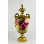 A Royal Worcester pedestal vase and cover by E Jarman, with dolphin twin handles, painted with roses
