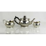 A silver tea set, comprising tea pot, sugar bowl and milk jug, engraved with crest and motto, London