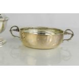A silver sifter, together with a silver shallow bowl with twin handles, 9toz.