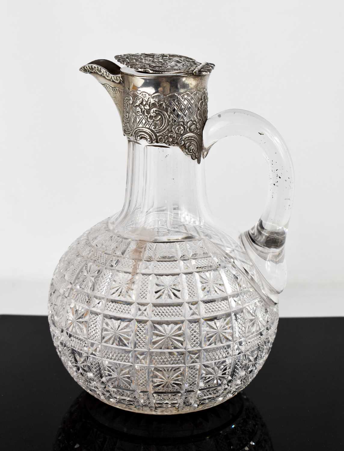 A 19th century silver and glass claret jug, with star hobnail panels, silver collar and cover