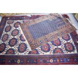 A Middle Eastern rug, the larges having a cream ground with red and blue border, 158 by 213cm,