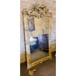 A large 19th century French wall mirror, carved with a crested top, painted in yellow with gilded