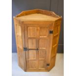 A Wilf Hutchinson 'Squirrelman' corner cabinet, with panelled door and hanging bracket.