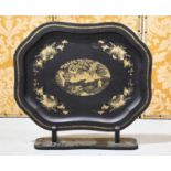 A Victorian black lacquered chinoiserie decorated tray on stand, hand gilded to depict a figural