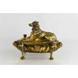 A 19th century gilt bronze inkstand, the cover in the form a recumbent dog, above the oval base cast