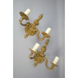 A pair of brass wall sconces with scroll decoration