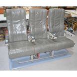 A set of three vintage aeroplane seats upholstered in grey leather