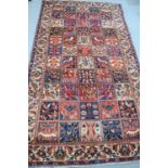 An Iranian Bakhtiar large wool rug with a cream border with Palmette motifs surrounding a panel of