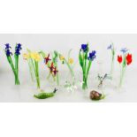 A group of vintage glass flowers in vases, a glass snail and caterpillar and other items