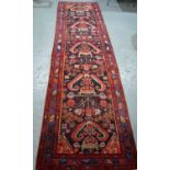 A late 19th century runner, with a red ground, 4m by 1.2m.